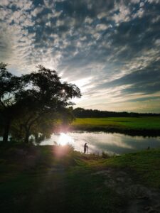 Photo d'un homme au bord d'un point d'eau au levé du soleil